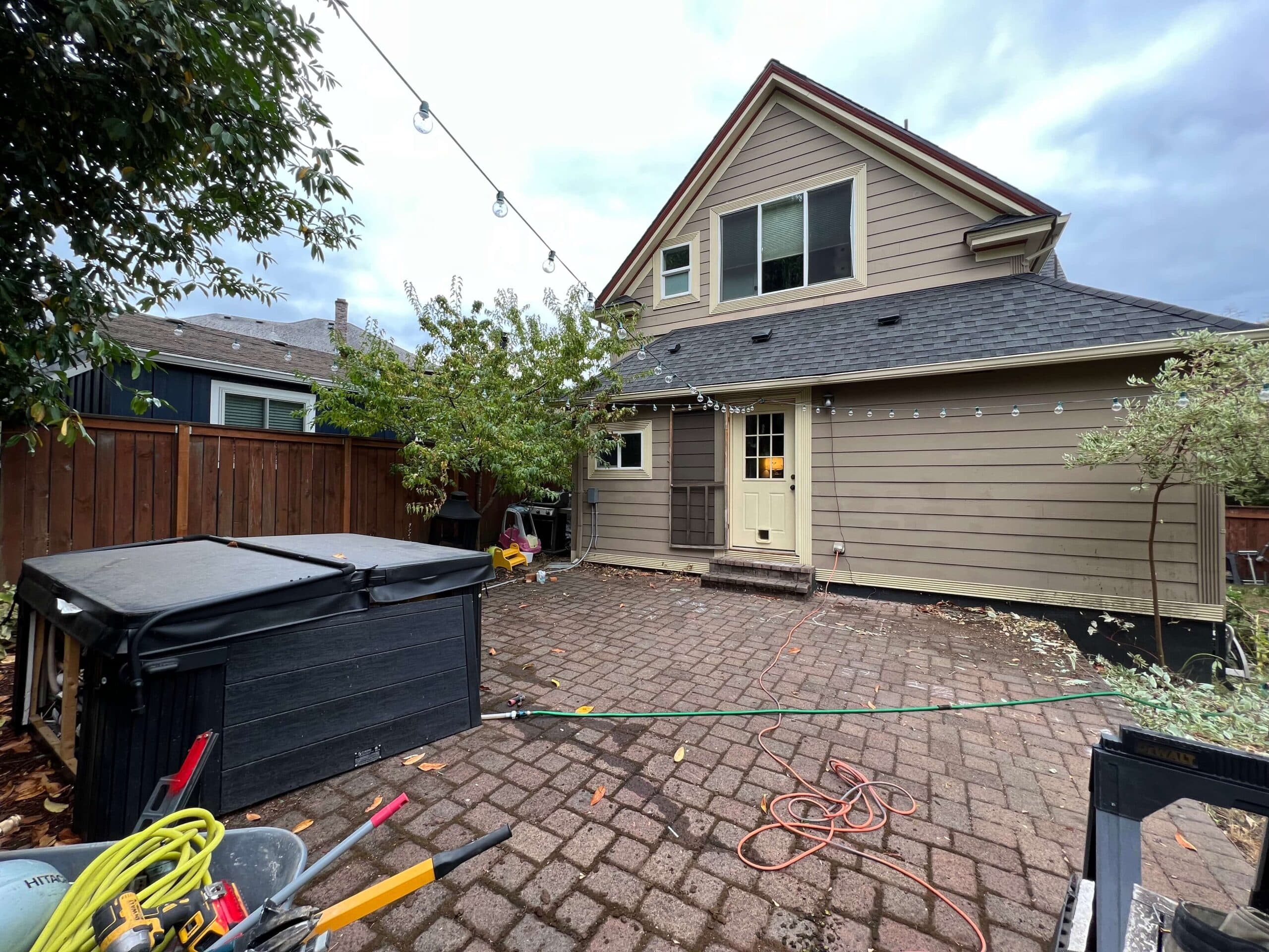 photo of a home with a brick paver patio that covers the backyard scaled